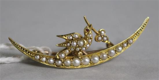 An Edwardian 15ct gold and seed pearl crescent and dove brooch, 39mm.
